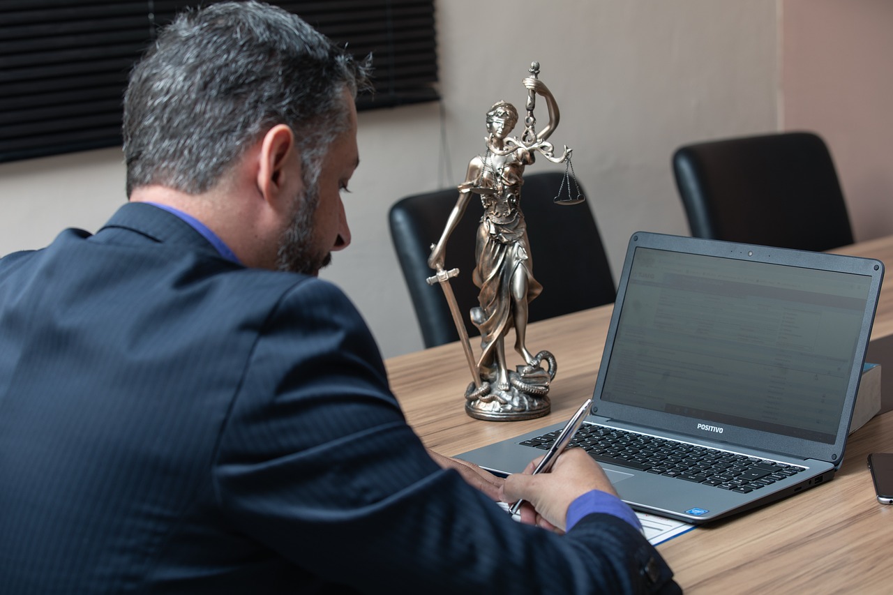Attorney reviewing documents with Lady Justice statue